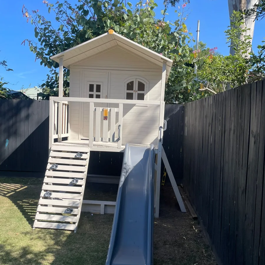 Kids cubby house with slide assembled in a backyard